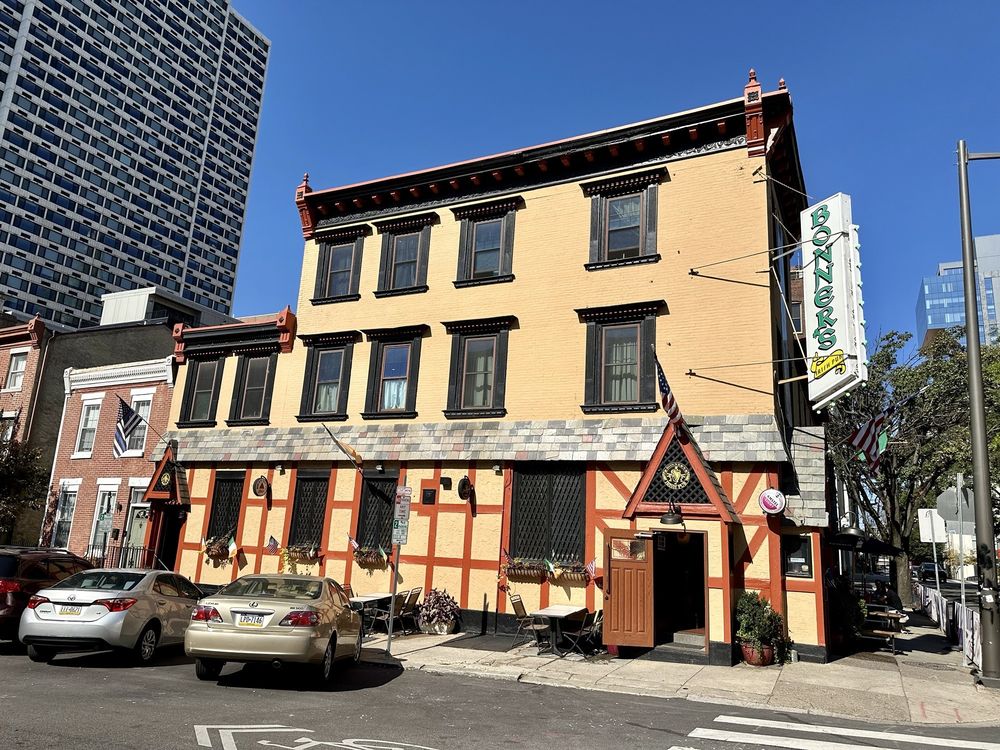 Exterior of Bonner's Irish Pub on 23rd Street, a half-timbered Tudor-style building with a green hanging sign and sidewalk tables out front.
